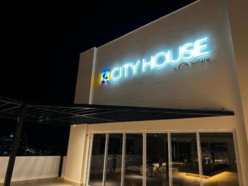 a cityhouse sign on the side of a building at night at Apartamentos Exclusivos no Edifício City House in Barreiras