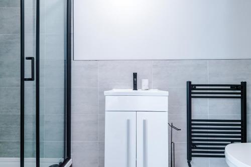 a bathroom with a sink and a shower at 3BR House By Eason Stays Short Term Rental Wythenshawe Near Manchester Airport with Free Parking in Wythenshawe