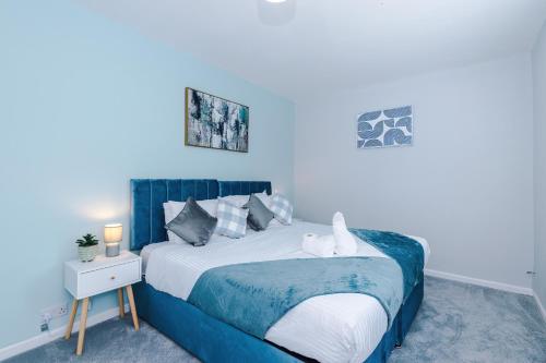 a blue bedroom with a bed with a blue wall at 3BR House By Eason Stays Short Term Rental Wythenshawe Near Manchester Airport with Free Parking in Wythenshawe