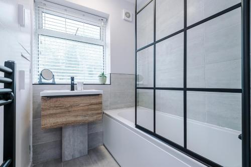 a bathroom with a tub and a sink and a shower at 3BR House By Eason Stays Short Term Rental Wythenshawe Near Manchester Airport with Free Parking in Wythenshawe