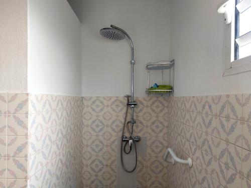 a shower with a shower head in a bathroom at TI-KAZ fleurie, l'escapade bouillonaise in LʼAjoupa-Bouillon