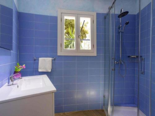 a blue bathroom with a sink and a shower at Charming Casa Encinar in Tranquil Residential Area in Sa Pobla