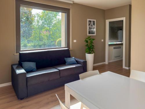 a living room with a couch and a large window at Alfredo Residence in Albiano dʼIvrea
