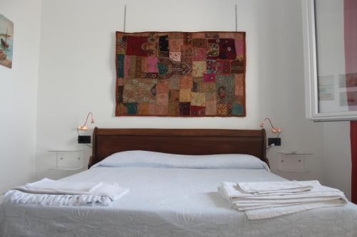 a bed with white sheets and towels on top of it at B&B Monterosso in Realmonte