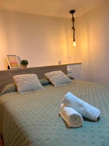 a bed with a pair of towels on it at Can Sablet in Horta de San Joan