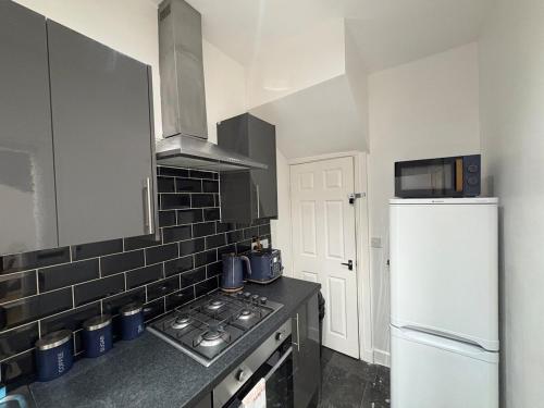 a kitchen with a stove and a refrigerator at Cliffton House, Sleeps 5, Parking,Netflix, WiFi, Only 6 min to City in Killingbeck