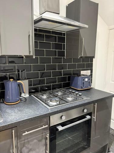 a kitchen with a stove top oven in a kitchen at Cliffton House, Sleeps 5, Parking,Netflix, WiFi, Only 6 min to City in Killingbeck