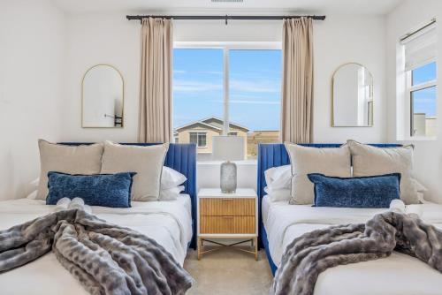 two beds in a room with a window at Luxury Resort Pool Spa Arcade Movie Gym in Mission Viejo