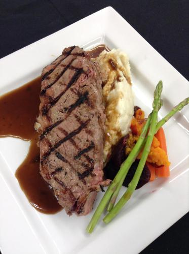 a plate of meat with mashed potatoes and green beans at Liscombe Lodge Resort & Conference Center in Liscomb