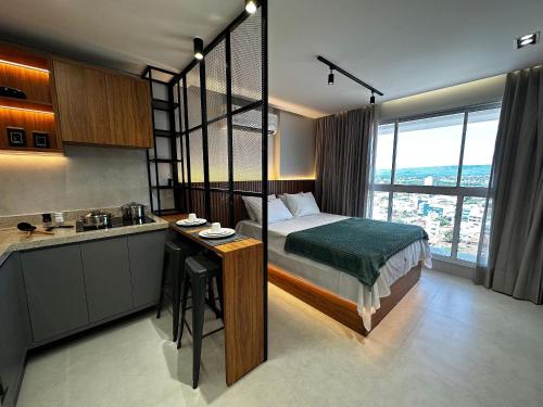 a bedroom with a bed and a kitchen with a sink at Apartamentos Exclusivos no Edifício City House in Barreiras