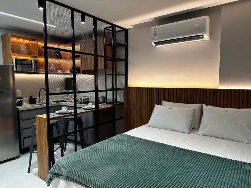 a bedroom with a bed and a kitchen at Apartamentos Exclusivos no Edifício City House in Barreiras