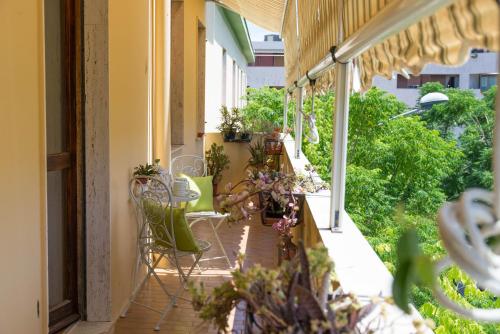 un balcon extérieur avec des chaises, des tables et des plantes dans l'établissement Sa Mama e Su Sole, à Alghero
