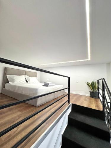 a bedroom with a large bed and a staircase at Nest Apartments in Tirana