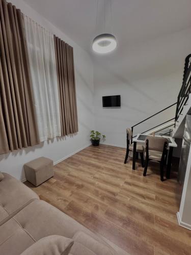 a living room with a couch and a staircase at Nest Apartments in Tirana