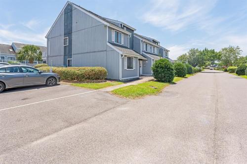 a house with a car parked on the side of a street at NEW! Large 1BR at The Golf Colony at Baytree, Pool in Stephens Crossroads