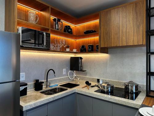 a kitchen with stainless steel appliances and wooden cabinets at Apartamentos Exclusivos no Edifício City House in Barreiras
