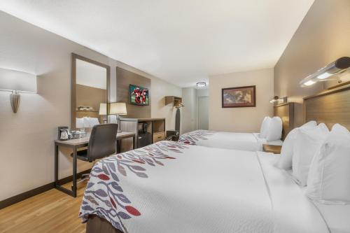 a hotel room with two beds and a desk at Red Roof Inn Erie – I-90 in Erie