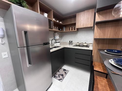 a kitchen with a stainless steel refrigerator at Apartamentos Exclusivos no Edifício City House in Barreiras