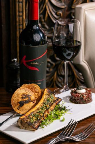 a plate with a bottle of wine and a glass at Grand Bohemian Lodge Asheville, Autograph Collection in Asheville