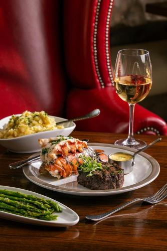 a table with two plates of food and a glass of wine at Grand Bohemian Lodge Asheville, Autograph Collection in Asheville