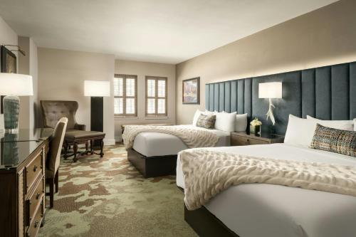 a hotel room with two beds and a desk at Grand Bohemian Lodge Asheville, Autograph Collection in Asheville