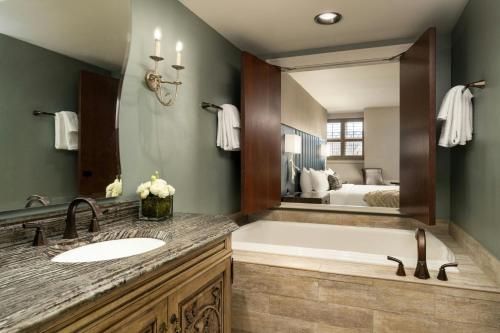 a bathroom with a tub and a sink and a mirror at Grand Bohemian Lodge Asheville, Autograph Collection in Asheville