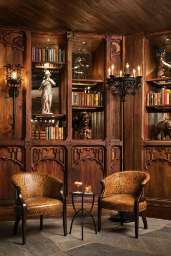 two chairs and a table in a room with bookshelves at Grand Bohemian Lodge Asheville, Autograph Collection in Asheville