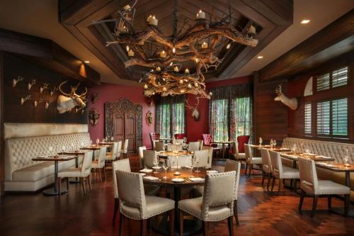 a dining room with tables and chairs and a chandelier at Grand Bohemian Lodge Asheville, Autograph Collection in Asheville