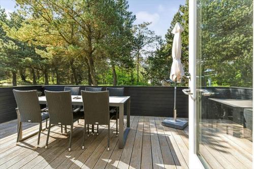 a patio with a table and chairs on a deck at BV395-Oksbol-Graevlingevej-1 in Oksbøl