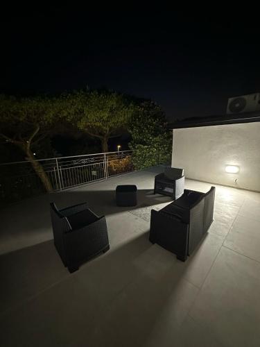 two chairs and a table on a patio at night at B&B Ai Templi Paestum in Stazione di Paestum