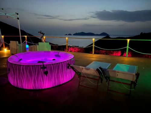 a hot tub on a deck at night at Palmaria Sky Bubbles Room in Ponza