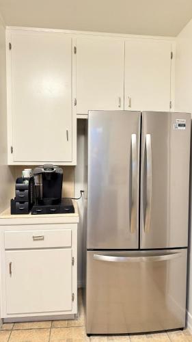 einen Kühlschrank aus Edelstahl in einer Küche mit weißen Schränken in der Unterkunft Upgraded 2B1B near to Old Town Pasadena Caltech in Pasadena