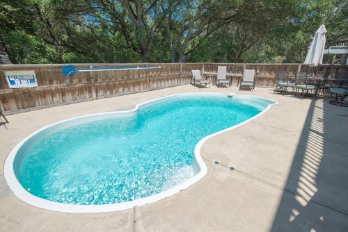 a swimming pool in a backyard with chairs and tables at Gone With the Wind in Duck