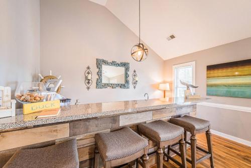 a kitchen with a large counter with stools at Gone With the Wind in Duck