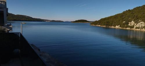 a large body of water next to a mountain at Vidučić Apartments in Dragove