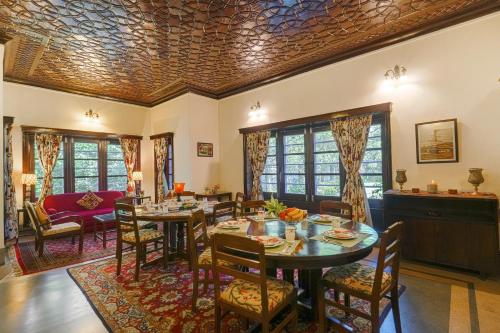 a dining room with a table and chairs at SaffronStays Awakening -Family Suite in Srinagar