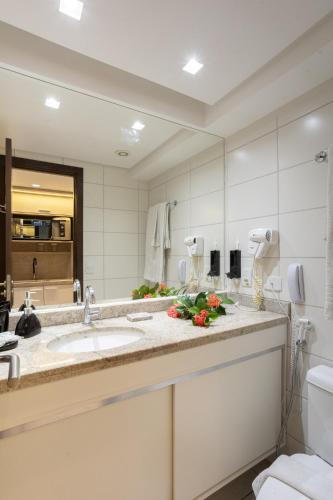 a bathroom with a sink and a large mirror at BEIRA MAR- FLAT EXECUTIVE in Recife