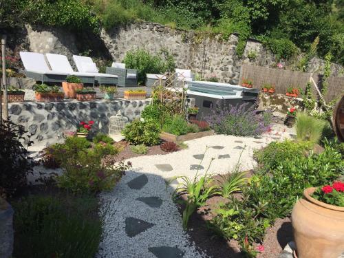 a garden with flowers and plants in front of a building at L'ESCALE DE CAMILLE in Murat