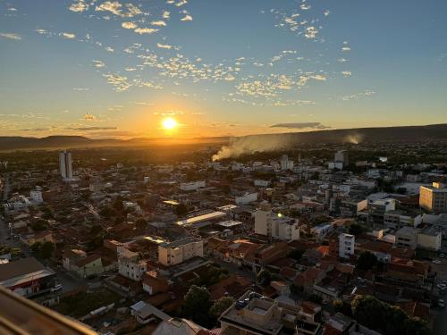 a view of a city with the sunset in the background at Apartamentos Exclusivos no Edifício City House in Barreiras
