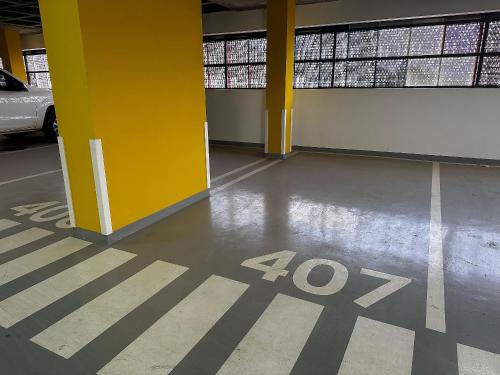an empty parking garage with a yellow column and a sign on the floor at Apartamentos Exclusivos no Edifício City House in Barreiras