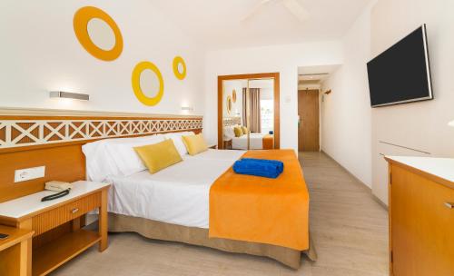 a bedroom with a bed and a desk and a tv at Globales Santa Ponsa Park in Santa Ponsa