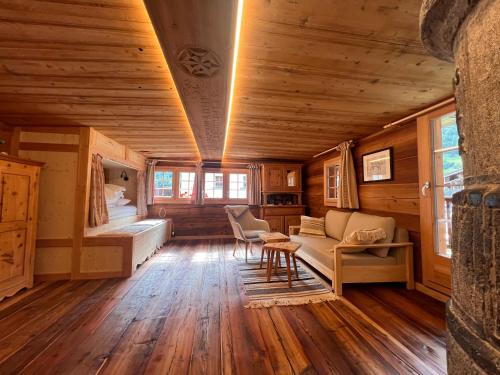 a room with a couch and a bed in a cabin at Studio de charme "Chez Alice" aux Haudères in Evolène