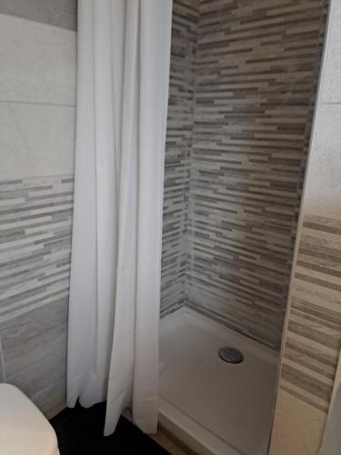 a shower with a white curtain in a bathroom at B&B Villa lucia in SantʼEufemia Lamezia