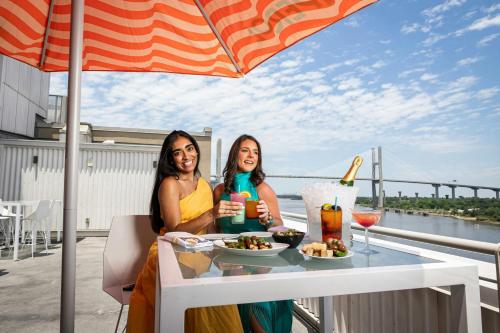 two women sitting at a table with food and drinks at JW Marriott Savannah Plant Riverside District in Savannah