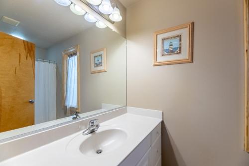 a white bathroom with a sink and a mirror at H&H III - K0020 in Kitty Hawk