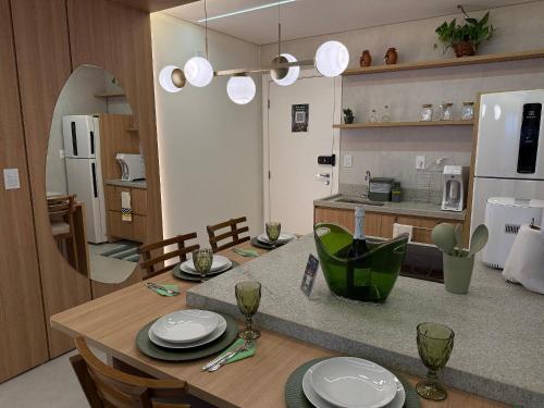 a kitchen and dining room with a table with plates on it at Apartamentos Exclusivos no Edifício City House in Barreiras