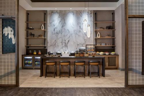 a kitchen with a table and some bar stools at Dallas-Addison Marriott Quorum by the Galleria in Addison