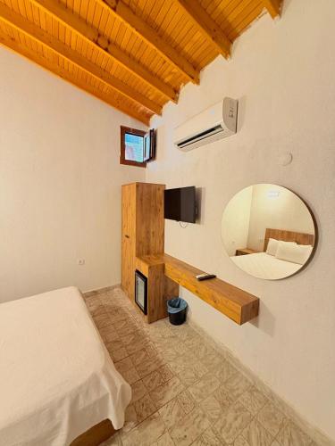 a bedroom with a bed and a mirror and a bed sidx sidx sidx at Ados Hotel in Çeşme