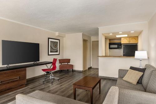 a living room with a couch and a desk in a room at Ramada by Wyndham Sarasota Waterfront in Sarasota