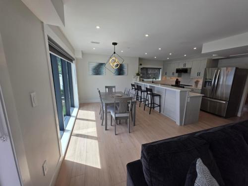 a kitchen and living room with a table and chairs at Premium Deluxe PeachView Suites 3BR in Peachland